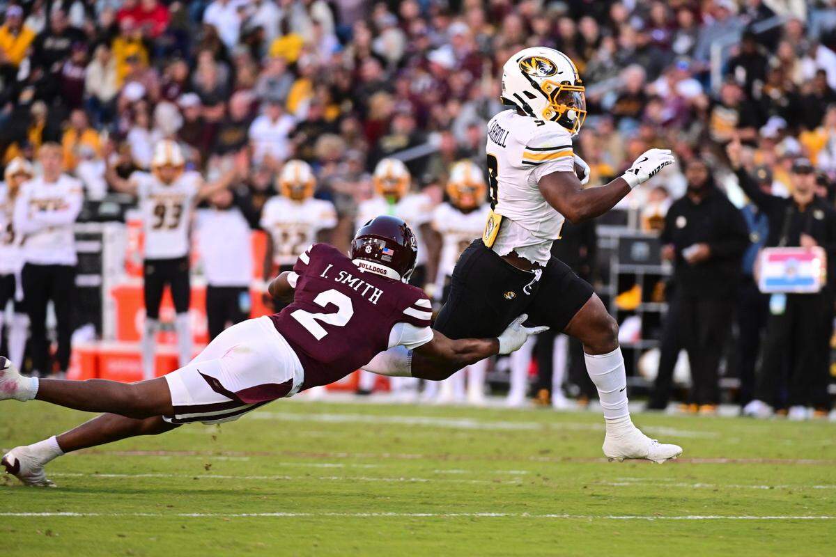 Missouri Tigers running back Marcus Carroll barrels past Mississippi State Bulldogs safety Isaac Smith during an SEC college football game at Davis Wade Stadium at Scott Field on Saturday, Nov. 23, 2024 in Starkville, Mississippi.