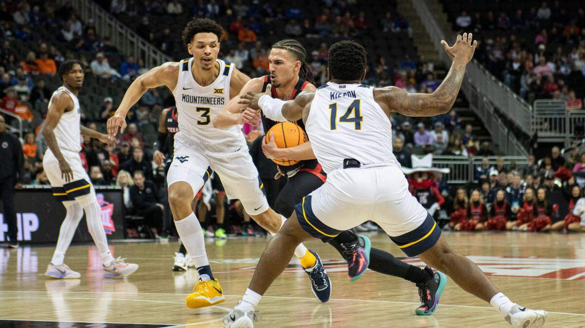 Texas Tech Red Raiders guard Pop Isaacs (2) dribbles the ball against West Virginia Mountaineers forward Tre Mitchell (3) and guard Seth Wilson (14) in the first half at T-Mobile Center on March 8, 2023.