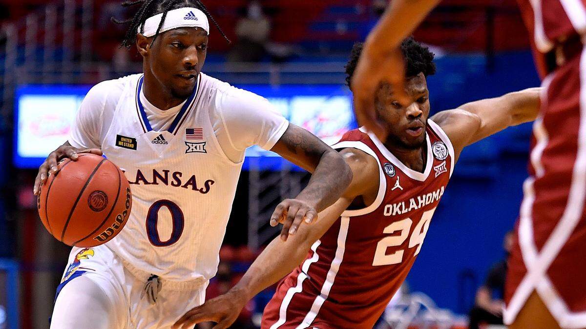 KU’s Marcus Garrett, left, got past OU’s Elijah Harless for a bucket during the second half of a Big 12 Conference game on Jan. 9, 2021 at Allen Fieldhouse. KU beat OU, 63-59.