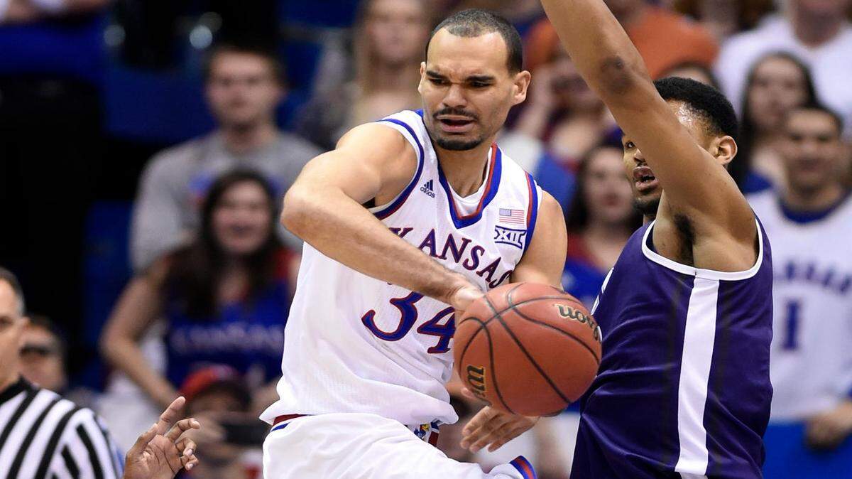 KU's Perry Ellis looks for an open teammate after running into TCU's Kenrich Williams during the first half of Saturday's game at Allen Fieldhouse.