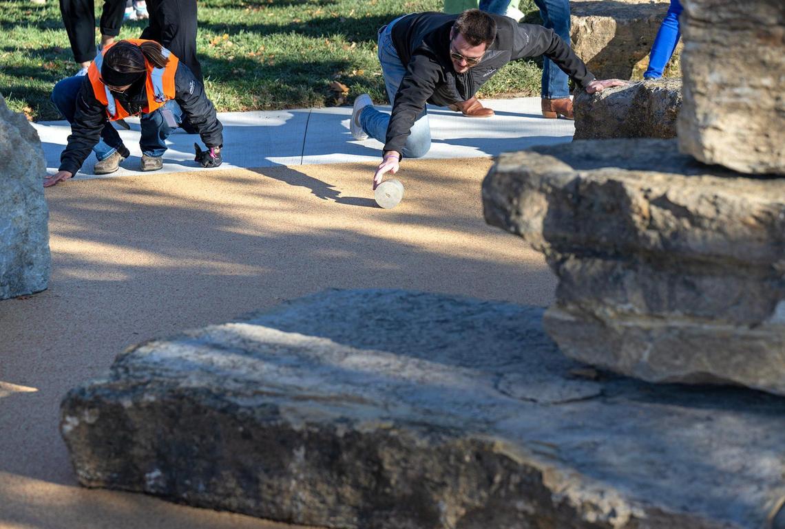 Jennifer Lyon left, and Grayson Brucato, both of JE Dunn Construction, use rollers to smooth out indentations in the poured-in-place surfacing at Riverfront Boulder @ Berkley.