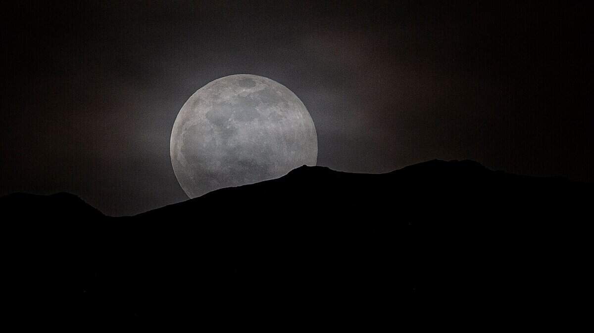 A pink moon rises over Bald Mountain on April 26, 2021, in Summit County, Colorado.