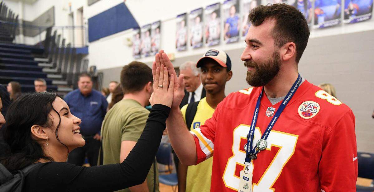 Gardner Edgerton High School teacher Matthew Mayeske exchanges a high-five with a student after receiving the Milken Educator Award at an all-school assembly.