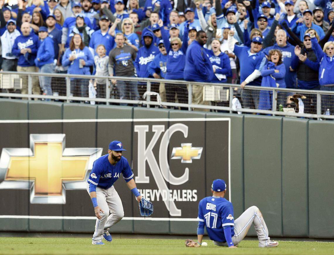 Toronto Blue Jays second baseman Ryan Goins sits on the ground and looks at the ball after he waved right fielder Jose Bautista off on a fly ball hit by Kansas City Royals second baseman Ben Zobrist in the seventh inning during Saturday’s ALCS baseball game on October 17, 2015 at Kauffman Stadium in Kansas City, Mo. Zobrist singled on the play.