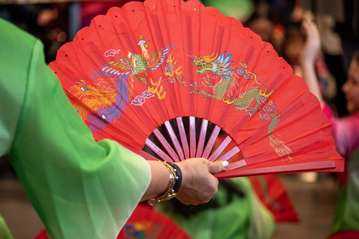 Performers wave a hand fan painted with a dragon during a Lunar New Year celebration at the Lenexa Public Market on Sunday, Feb. 22, 2026, in Lenexa, Kan.