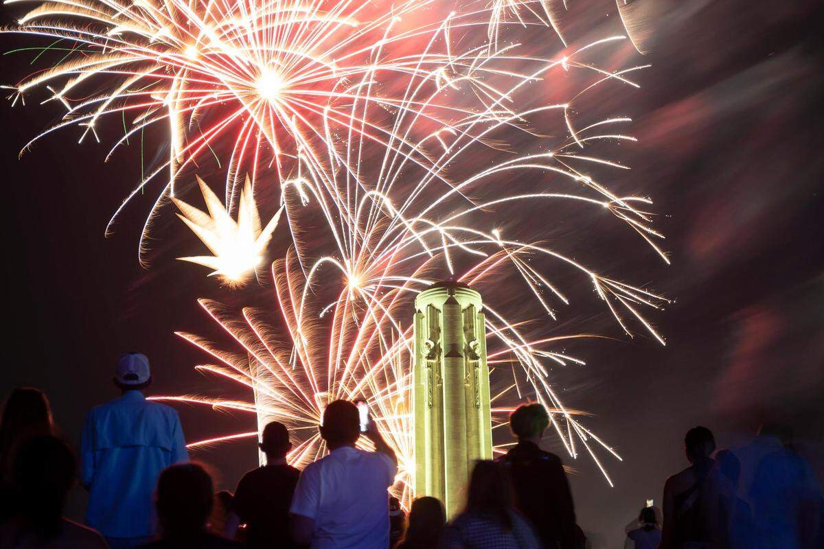 People watch and record fireworks as they explode over the Liberty Memorial and the National World War I Museum at the end of the Celebration at the Station, an event featuring the Kansas City Symphony to celebrate and commemorate Memorial Day on Sunday, May 29, 2022, in Kansas City.