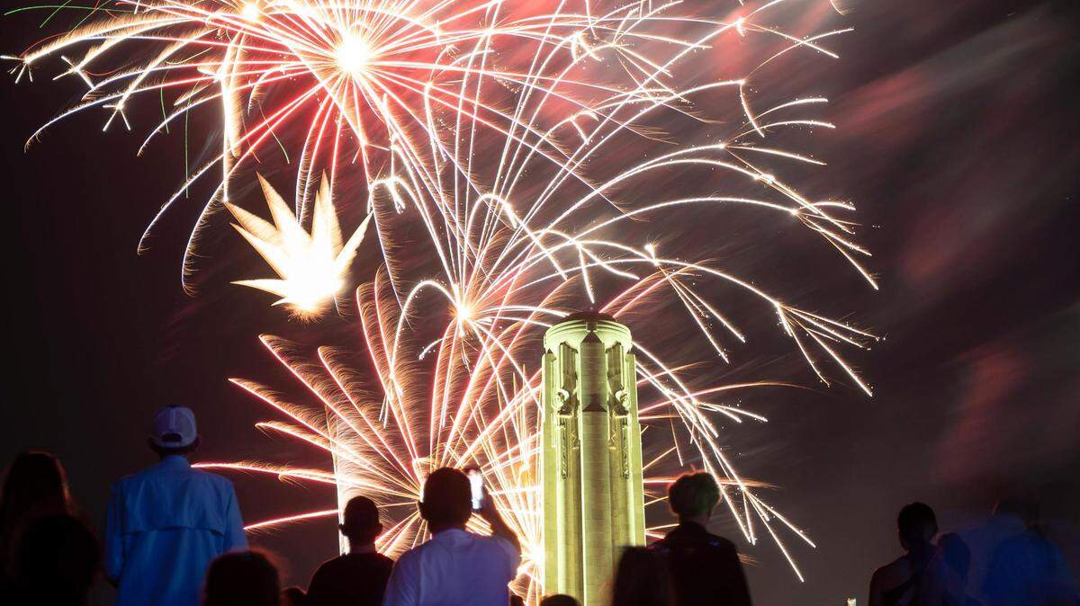 People watch and record fireworks as they explode over the Liberty Memorial and the National World War I Museum at the end of the Celebration at the Station, an event featuring the Kansas City Symphony to celebrate and commemorate Memorial Day on Sunday, May 29, 2022, in Kansas City.