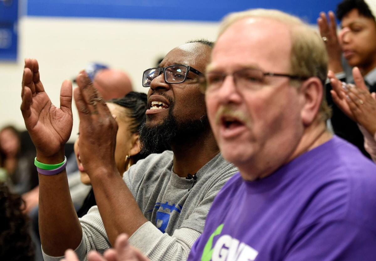 Christopher Hutson, left, lost his son two years ago when he was shot and killed in a road rage incident. the 19-year-old was an organ donor and Gary Dixon, front, was the recipient his heart. Dixon is now close friends of the Hutson family, and joins them to watch Desmond Hutson, a Raytown High School senior, play basketball.