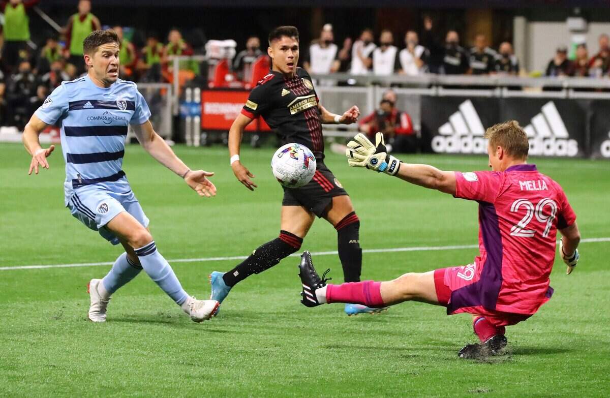 Atlanta United’s Luiz De Araujo, center, scores a goal past Sporting Kansas City goalkeeper Tim Melia, right, during the teams’ MLS opener last Sunday in Atlanta.