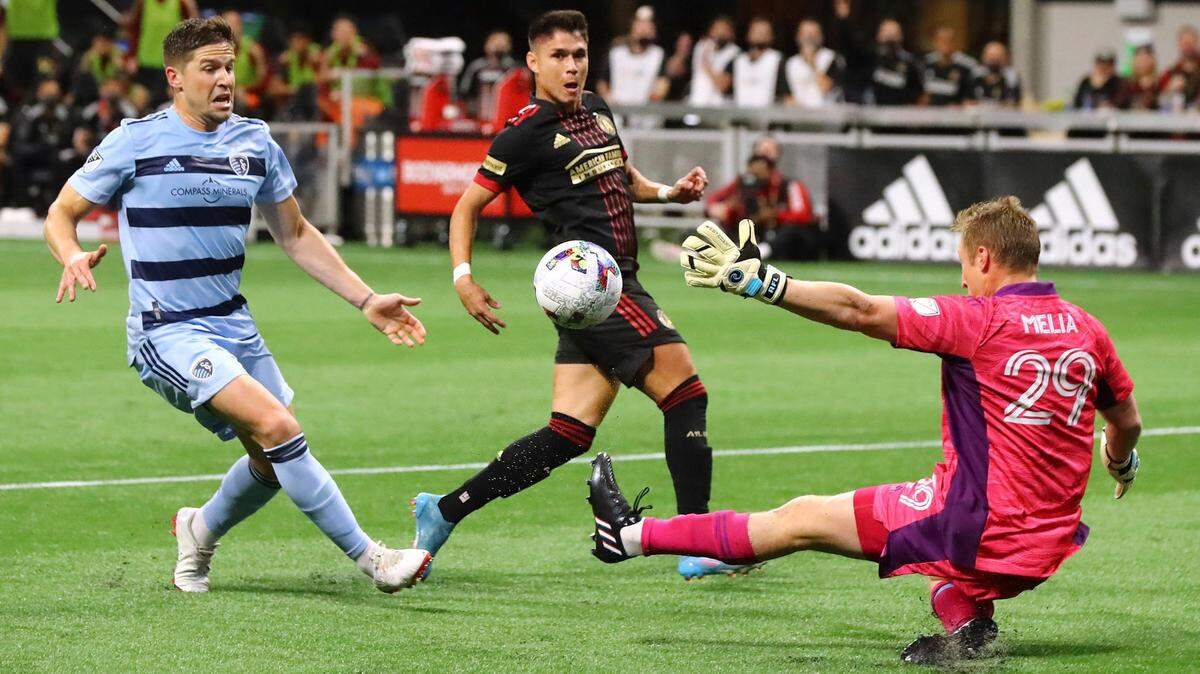 Atlanta United’s Luiz De Araujo, center, scores a goal past Sporting Kansas City goalkeeper Tim Melia, right, during the teams’ MLS opener on Sunday in Atlanta.