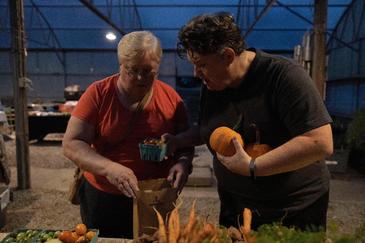 Kathy Burlison and Eileen Brewer pick up some vegetables from the KC Farm School, which holds a farmer’s market on Gibbs Road in Kansas City, Kansas, from May to November.