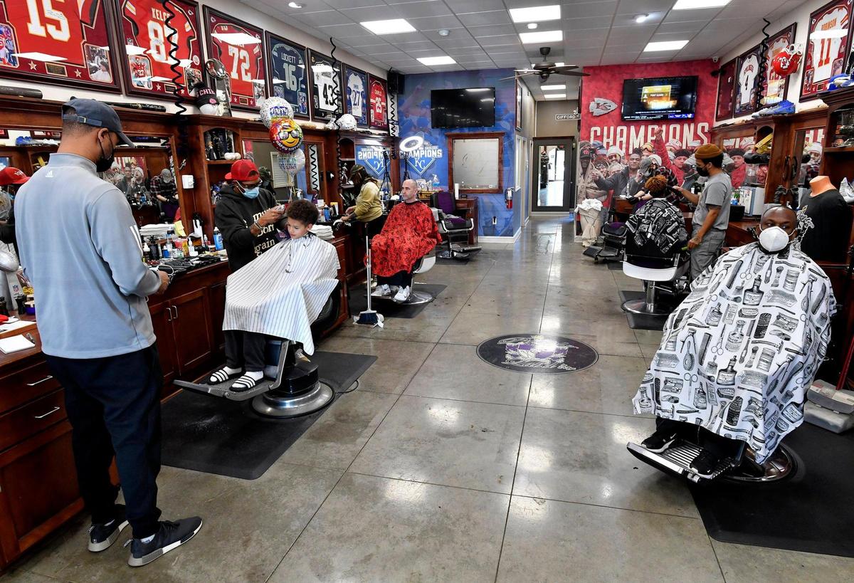 DeJuan Bonds, in the red hat, owns Purple Label Luxury Barber Shop by Napps in Overland Park, where Chiefs quarterback Patrick Mahomes gets his iconic hairstyle cut. Lining the walls are framed sports jerseys of Bonds’ most famous MLB and NFL clients, including Lorenzo Cain. Alex Gordon, Mecole Hardman and Travis Kelce — the teammate who first told Mahomes about the shop.