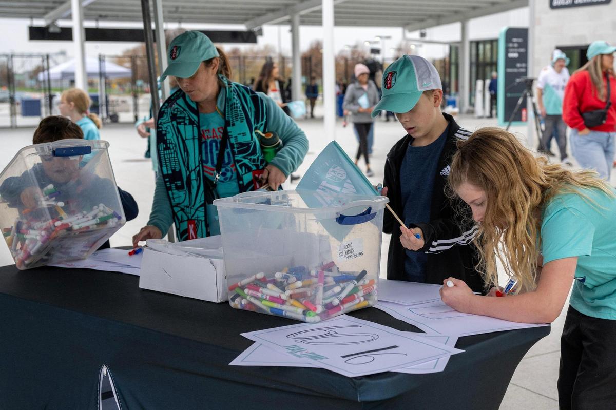 Fans create signs at the sign-making station before a watch party at CPKC Stadium for the semifinal match between the Kansas City Current and Orlando Pride on Sunday, Nov. 17, 2024, in Kansas City.