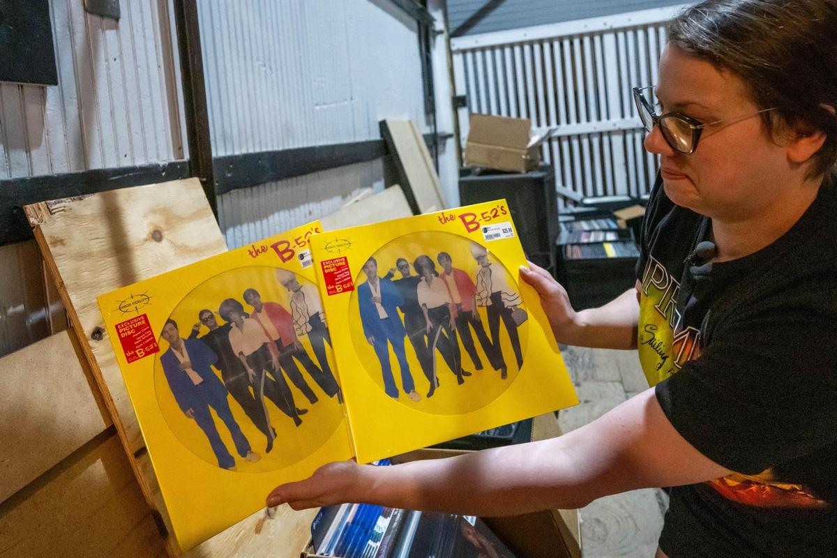 Celia Albon, an employee at Josey Records, shows a pair of exclusive vinyls from the band the B-52’s, on Friday, April 11, 2025, the day before Record Store Day.
