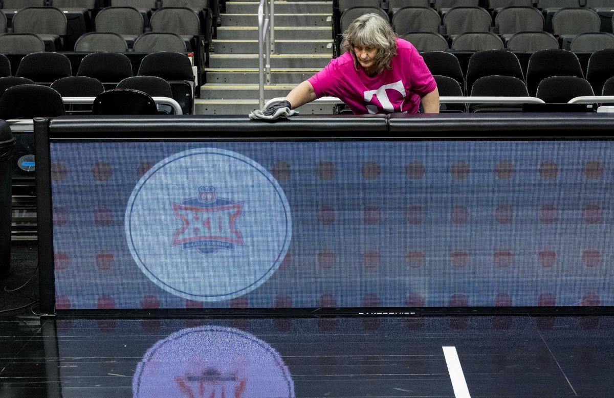 Kristie Morey, environmental services lead at T-Mobile Center, cleans a portion of the scorer’s table Tuesday during the Big 12 basketball tournament.