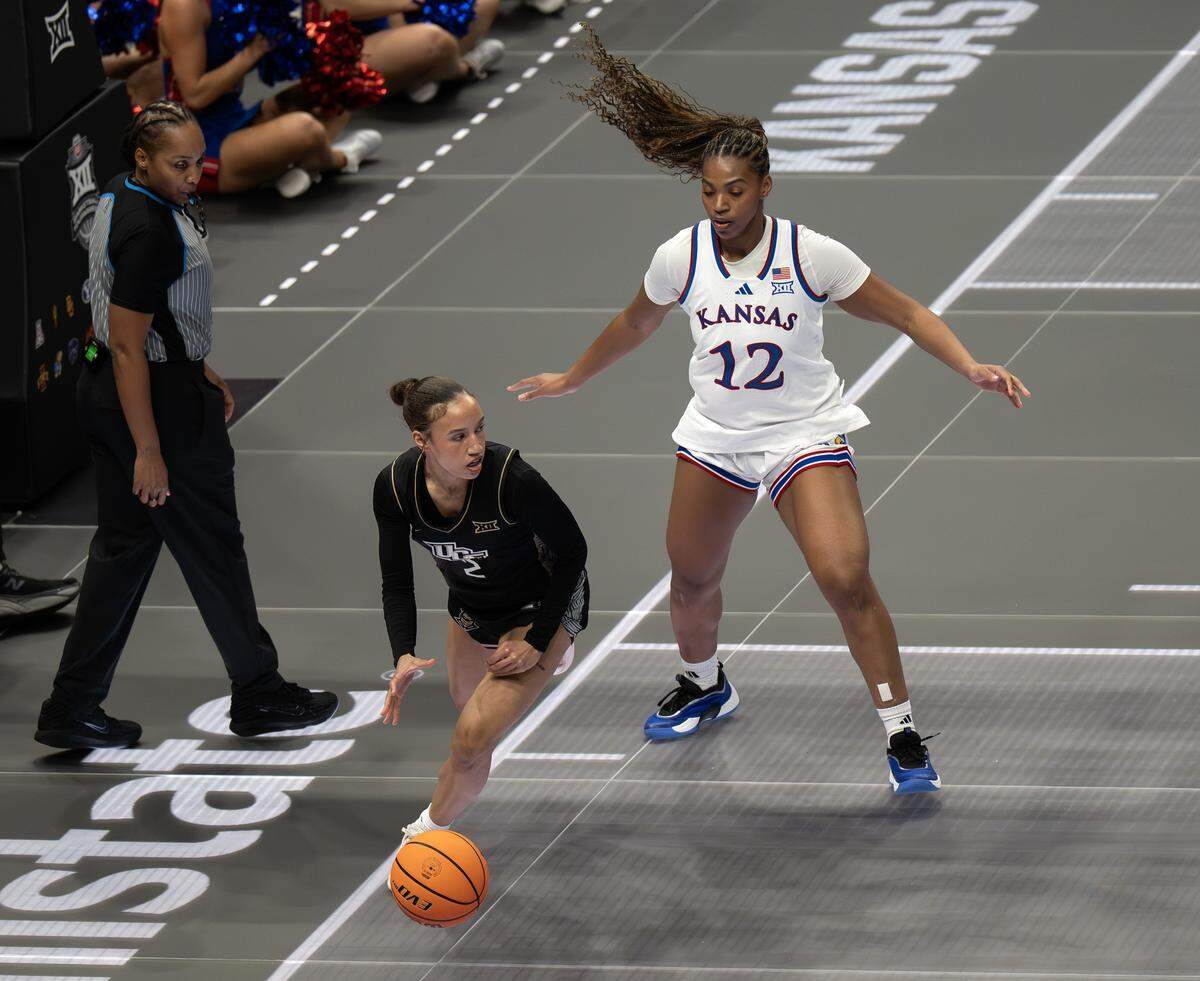 UCF Knights guard Kristol Ayson (2) shields the ball from Kansas Jayhawks guard S'mya Nichols (12) during the first quarter of the Big 12 Women's Basketball Tournament at T-Mobile Center on Wednesday, March 4, 2026, in Kansas City.