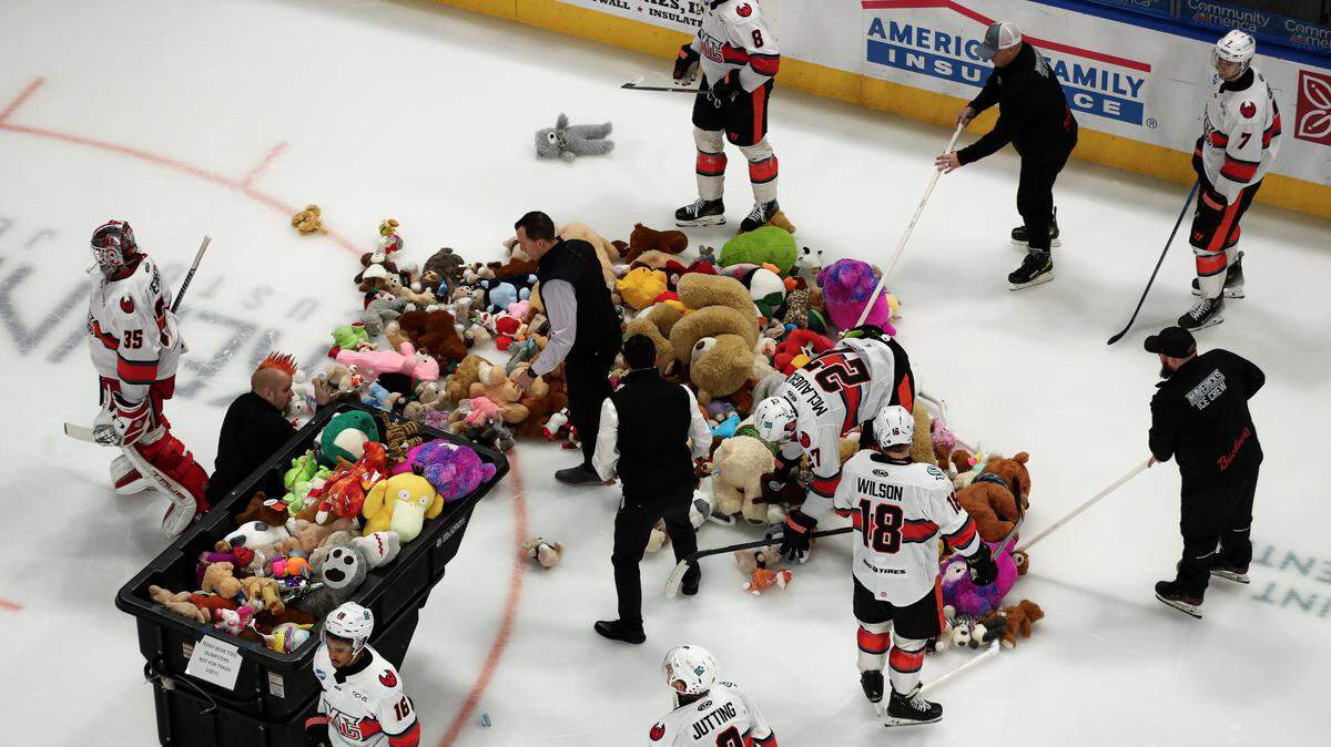 Kansas City Mavericks players help gather up teddy bears tossed onto the ice by charitable fans during the team’s Teddy Bear Game at Cable Dahmer Arena in Independence, Missouri on Saturday, Dec. 20, 2025.