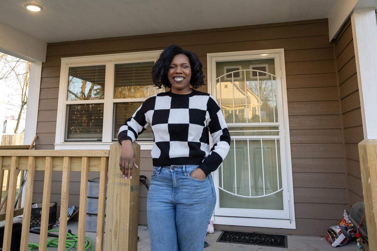 LaToya Jordan stands on the porch of her new home she owns in Kansas City’s Lykins neighborhood, built by Habitat for Humanity. Jordan and her five children occupied the home in September. 
