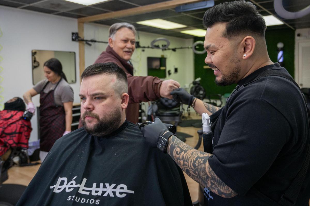Josh Pacubas trims Clint Rosewell’s hair at his barbershop Dé Luxe Studios in Mission. As an adult, Pacubas worked a variety of jobs that he said left him feeling unfulfilled. It wasn’t until a friend suggested barbering that he seemed to find his calling.