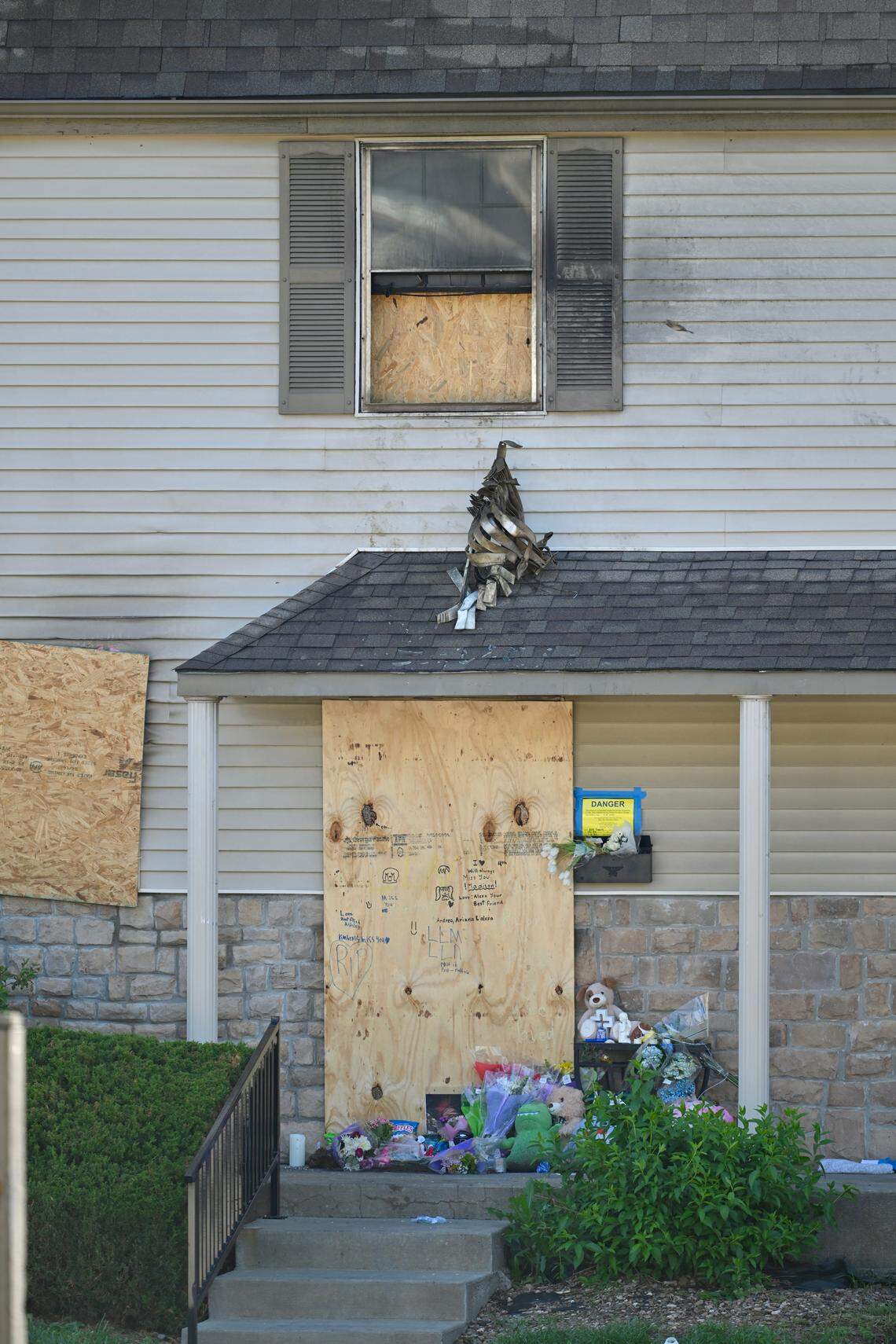 A memorial with flowers, stuffed animals and handwritten notes on a boarded door sits outside the Overland Park apartment where a Saturday morning fire killed a brother and sister and injured three other members of their family. The memorial, pictured on Friday, April 24, is part of support and donations coming in for the family.