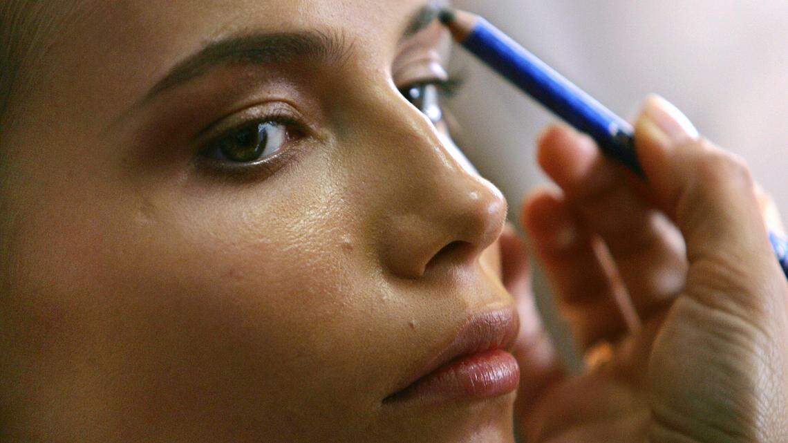 a woman putting on her makeup.