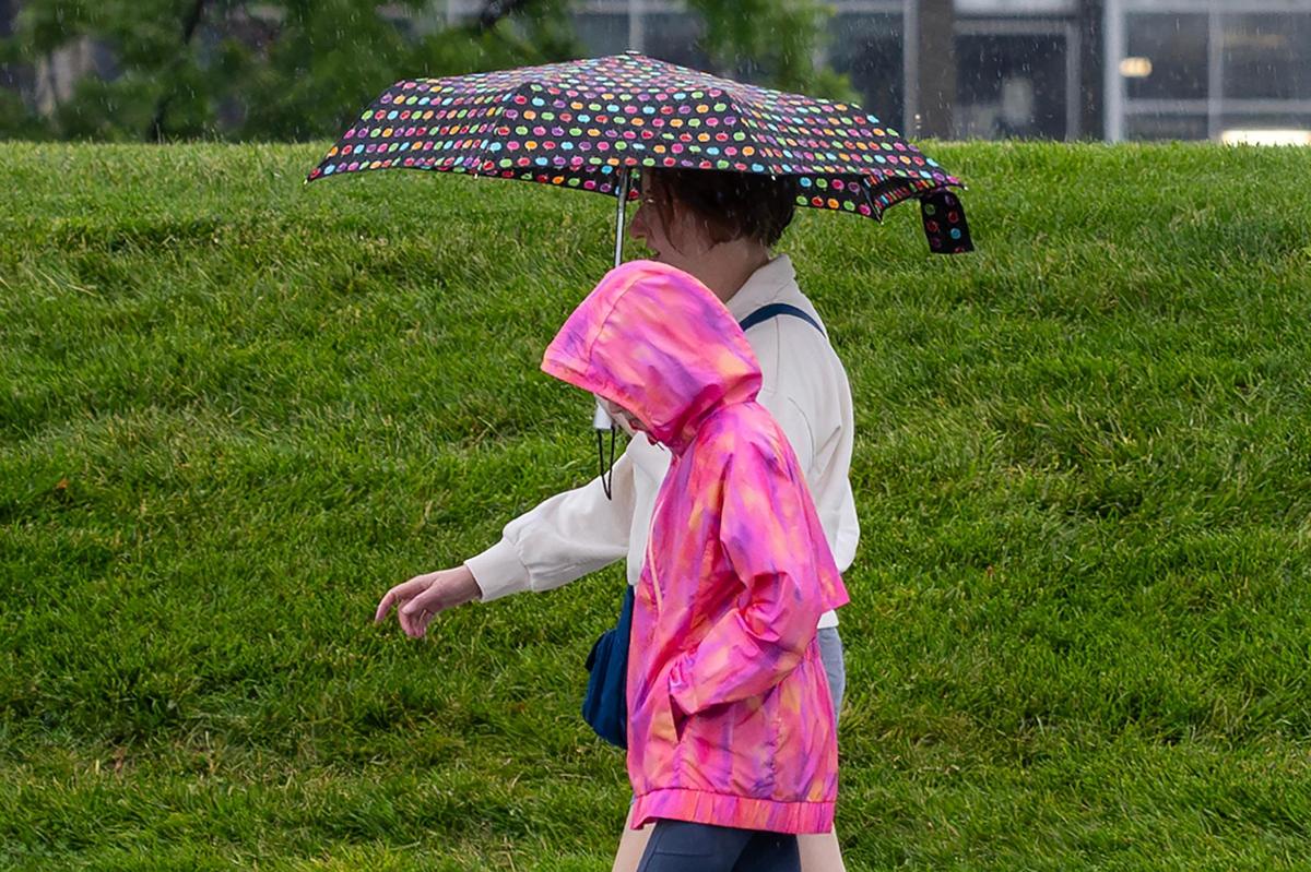 Visitors walk under an umbrella through the rain to the National WWI Museum and Memorial on Tuesday, June 3, 2025, in Kansas City.