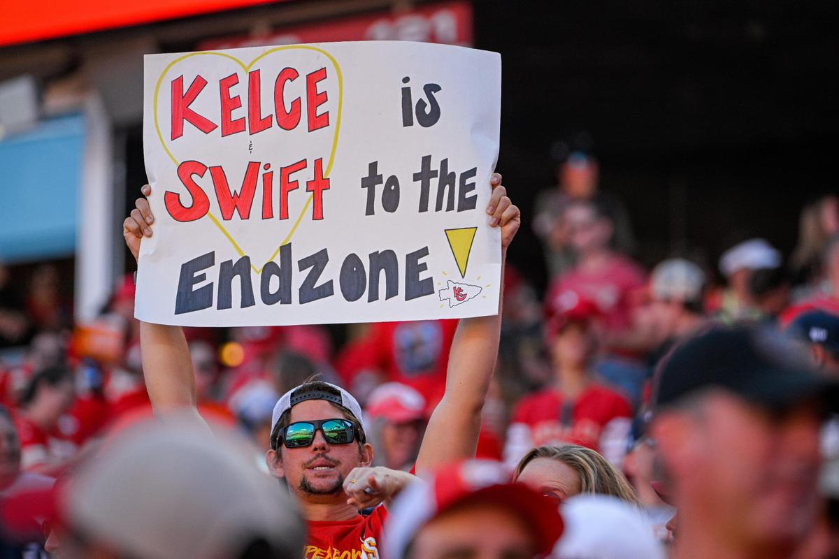A fan holds up a sign in reference to Taylor Swift and Travis Kelce Sunday, Sept. 24, 2023, at GEHA Field at Arrowhead Stadium.