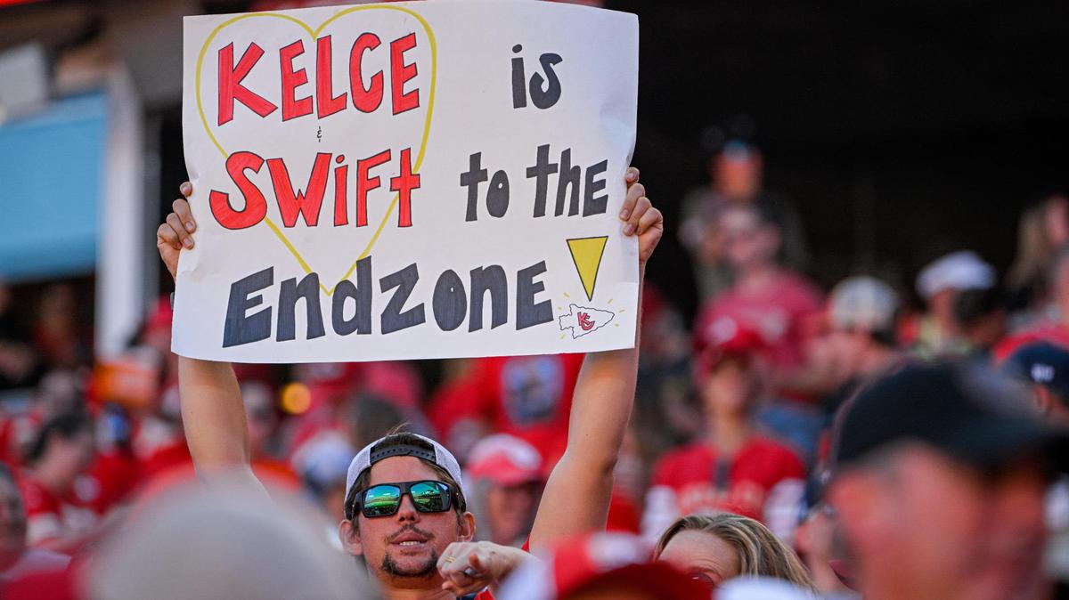 A fan holds up a sign in reference to Taylor Swift and Travis Kelce Sunday, Sept. 24, 2023, at GEHA Field at Arrowhead Stadium.