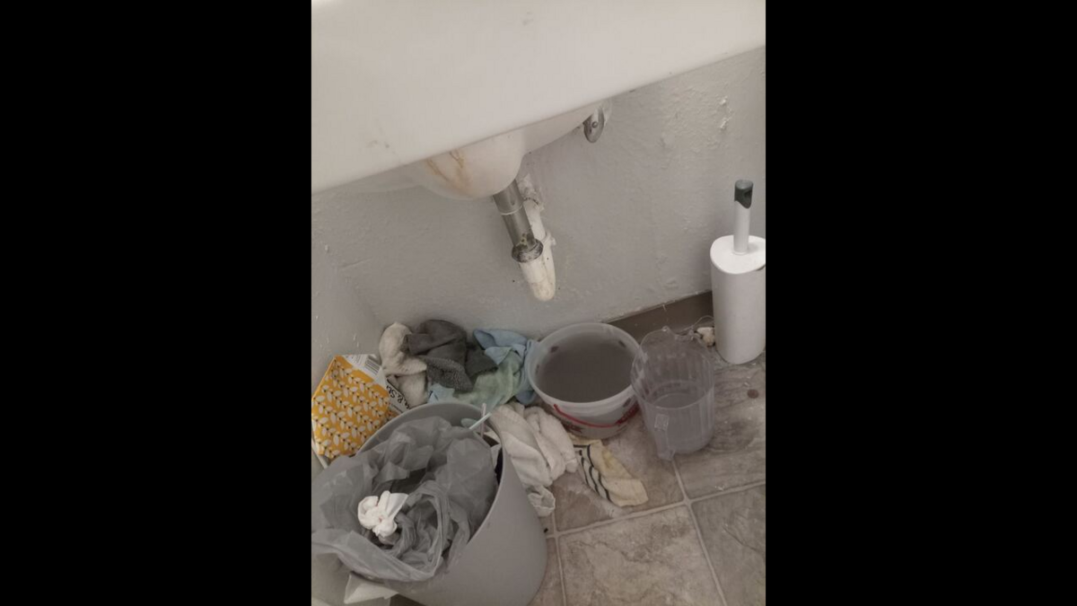 A photo of Elijah Brink’s bathroom sink leaking onto the floor.