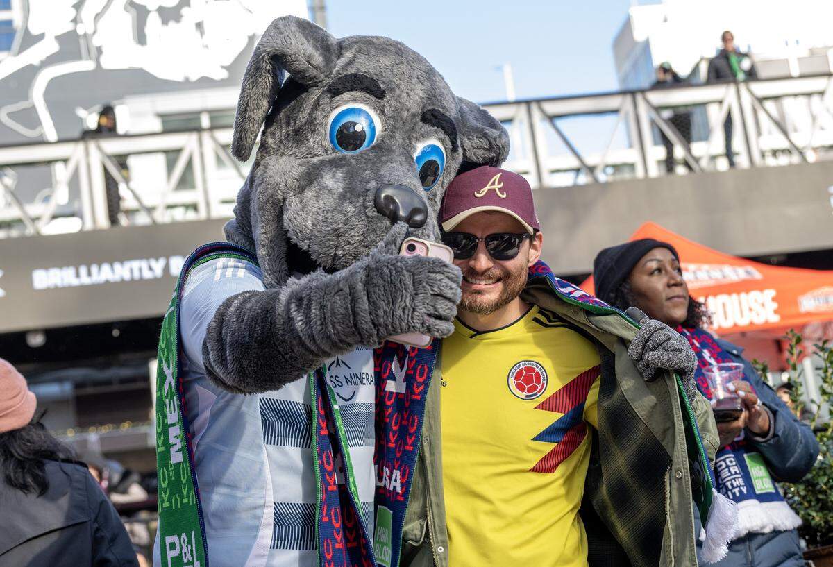 Blue, the Sporting KC mascot, poses for a photo with a Colombia fan during the FIFA World Cup draw watch party at the Power & Light District on Friday, Dec. 5, 2025, in Kansas City.