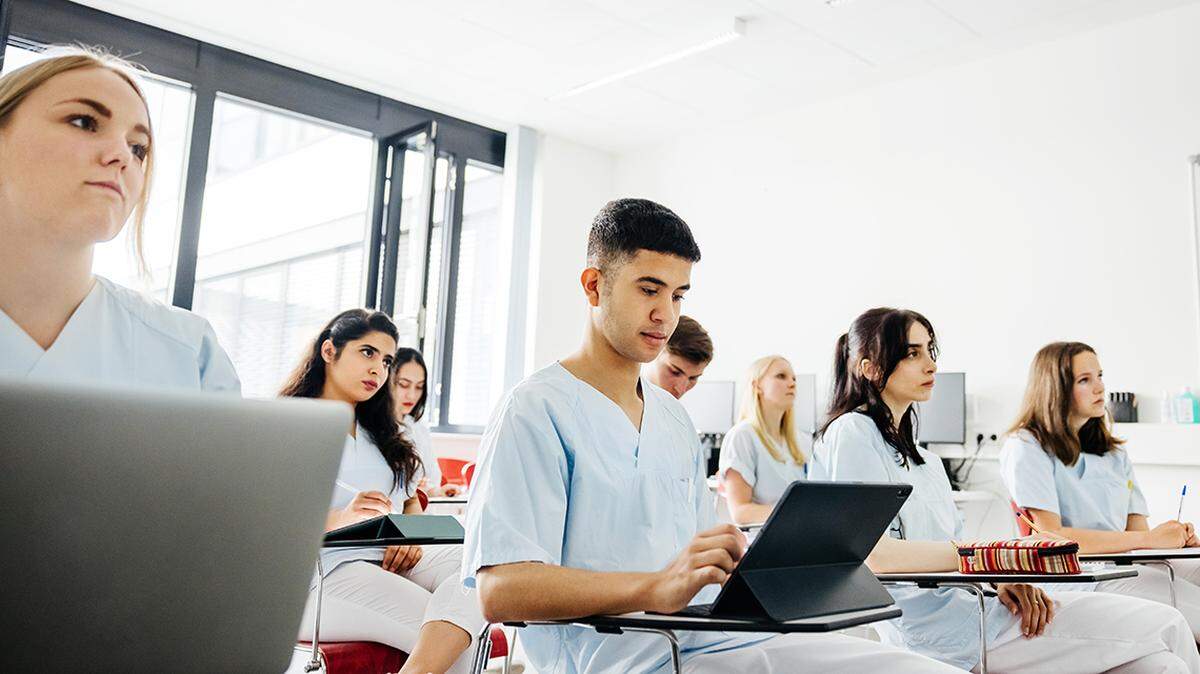 A group of student dentists typing on their laptops while working during a university lecture. nurse nursing