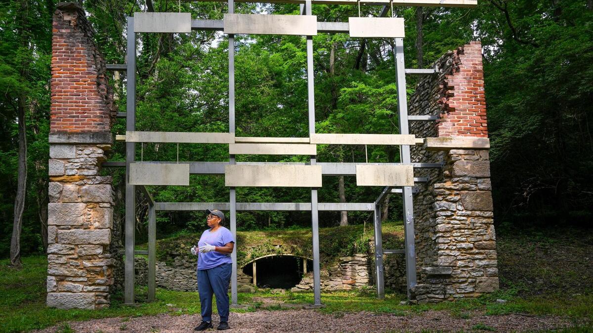 The Rev. Stacy Evans paused near the ruins of an old brew house in the Quindaro Ruins on Saturday, June 3, 2023, in Kansas City, Kansas. A brew cave, where beer was kept cool, can be seen in the center. Evans, who chairs the Quindaro Ruins Project Foundation board, is spearheading an effort to revitalize the Quindaro Ruins, which was once a stop on the Underground Railroad. The ruins of the brew house have been stabilized.