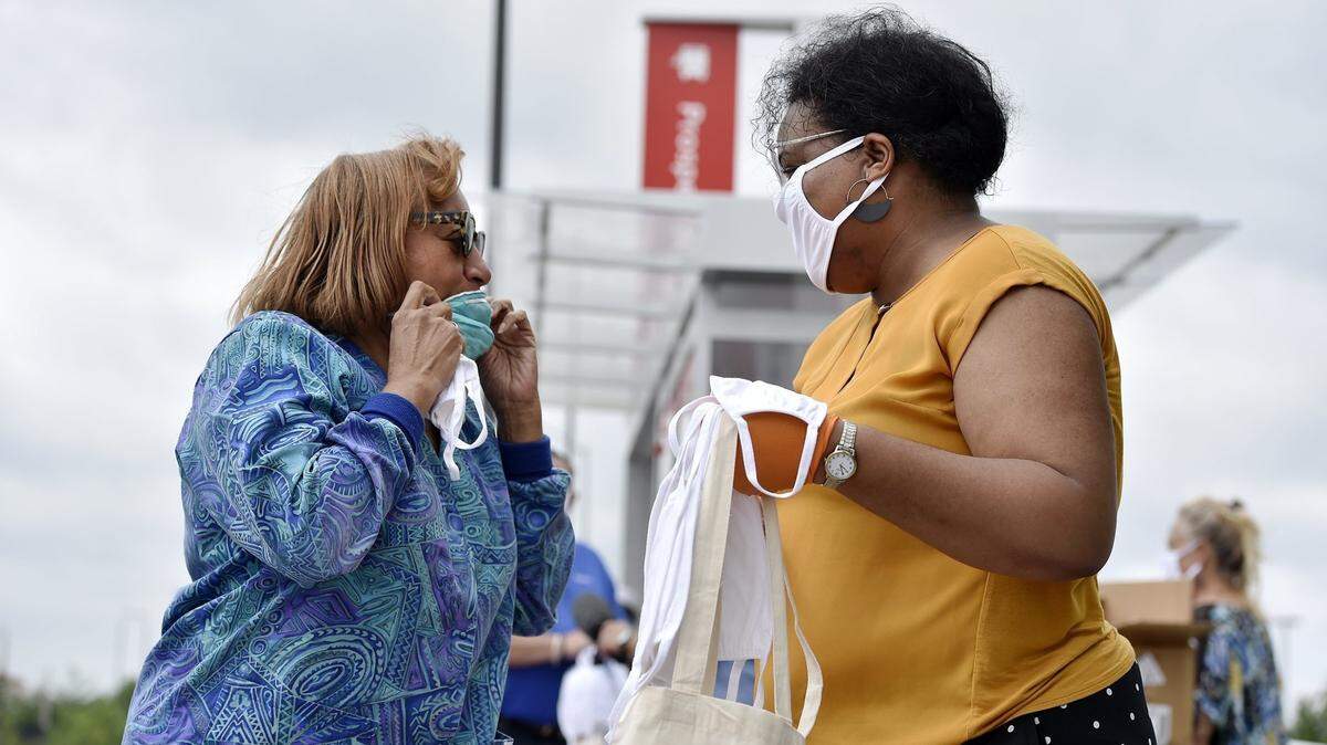 Melissa Robinson, 3rd District councilwoman, right, helped distribute masks at a bus stop at 31st Street and Prospect Avenue Tuesday, June 30, 2020.