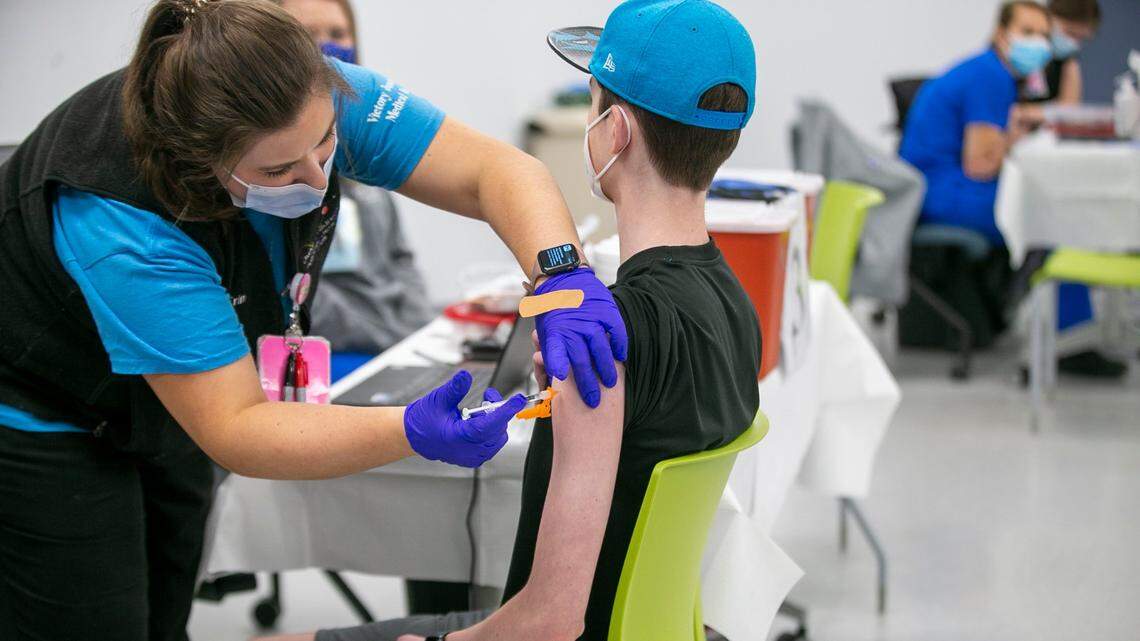 Erin Morgan, a registered nurse, administers the Pfizer COVID-19 vaccine to 14-year-old Zach Bilyj of Wake Forest, North Carolina, during a vaccination clinic. Kids ages 12 and up are eligible for the shot.