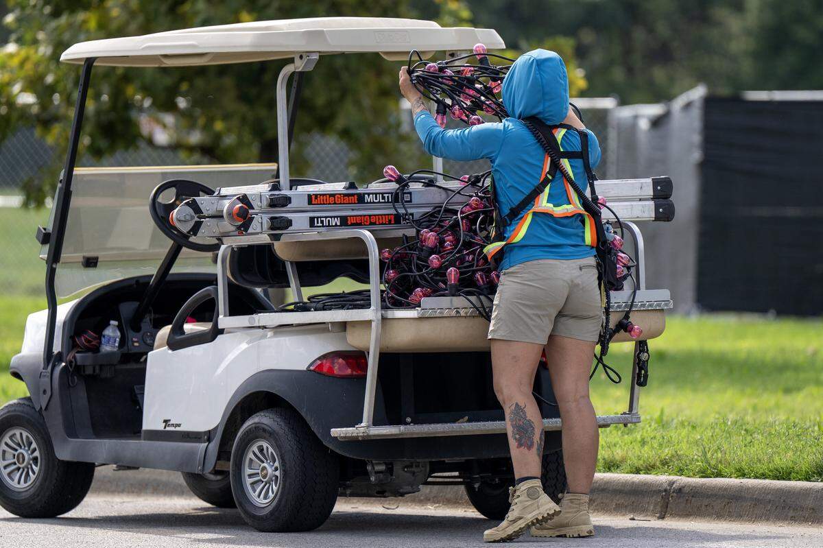 An event staffer loads a golf cart with pink patio lights outside the National WWI Museum and Memorial on Wednesday, Oct. 1, 2025, in Kansas City, ahead of pop singer Chappell Roan's concert Visions of Damsels and Other Dangerous Things. 
