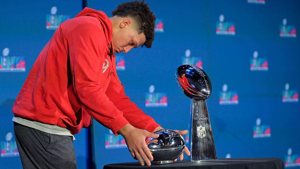 Chiefs quarterback Patrick Mahomes looks over the Pete Rozelle (Super Bowl MVP) and Lombardi trophies during a Monday morning post-Super Bowl meeting with reporters at the Phoenix Convention Center.
