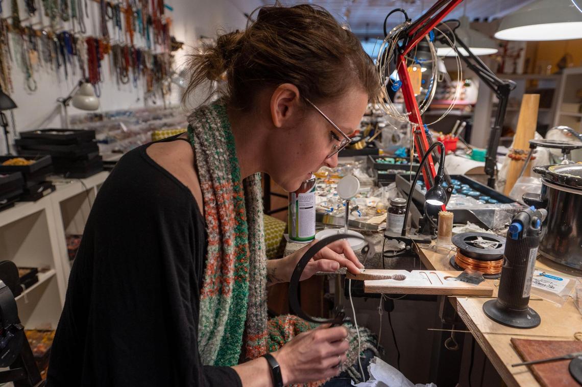Jewelry designer Brianna Zimmerling sculpts a small piece of metal at Small World Gallery in Lindsborg. The business, started by Jim and Kathy Richardson, has grown to a sprawling operation with local art and retail up front and production areas in the back.