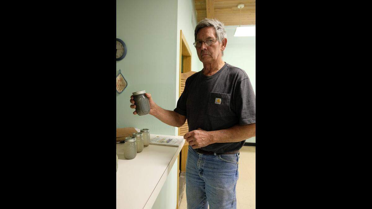 Rodney Biesenthal holds up a water sample he collected from runoff near a rock quarry in Pottawatomie County. Some of the samples have been tested at Kansas State University.