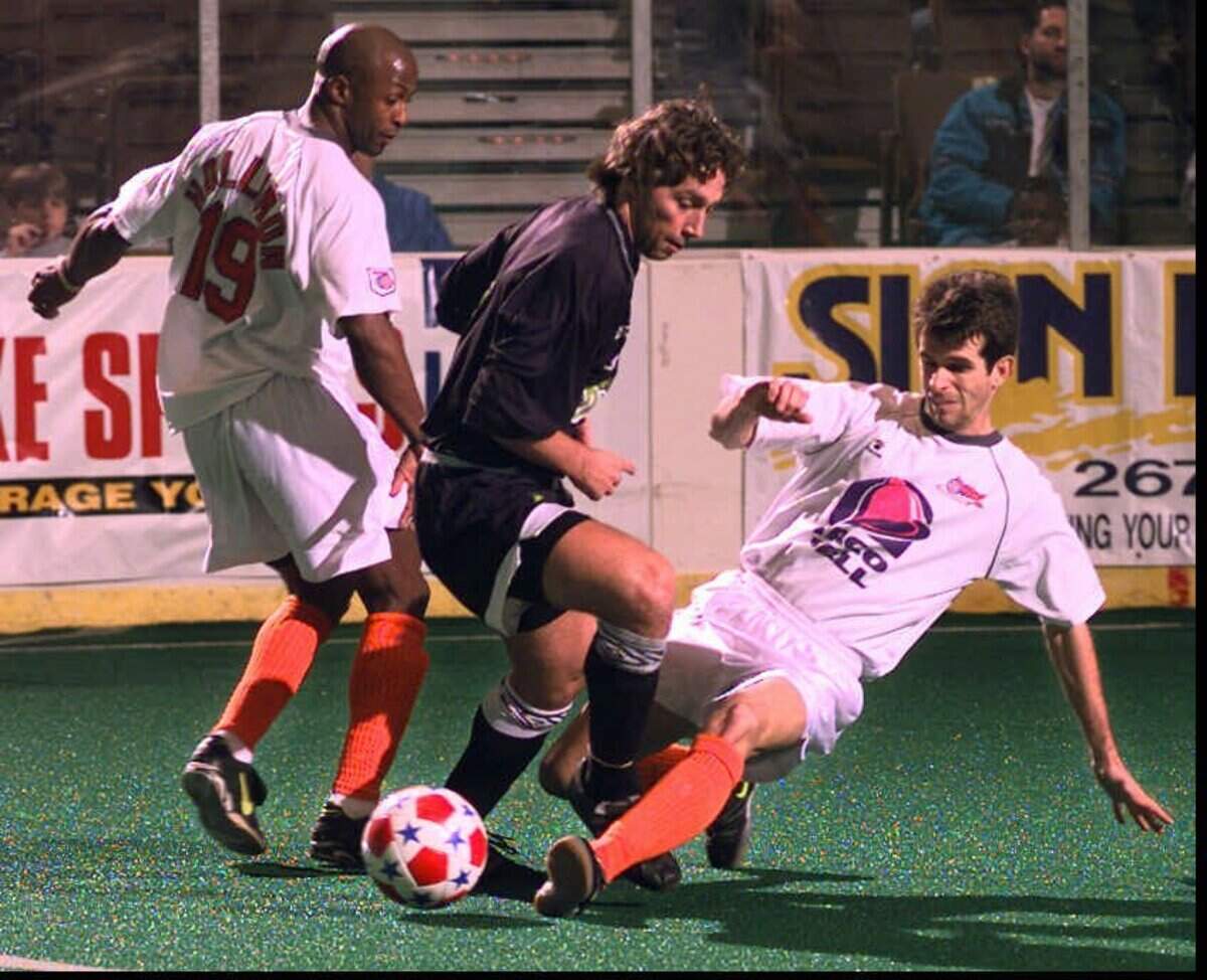 Wichita Wings Tommy Knox makes a slide tackle against Edmonton’s Nick DeSantis in the first period while LeBaron Hollimon stands nearby. Travis Heying photo