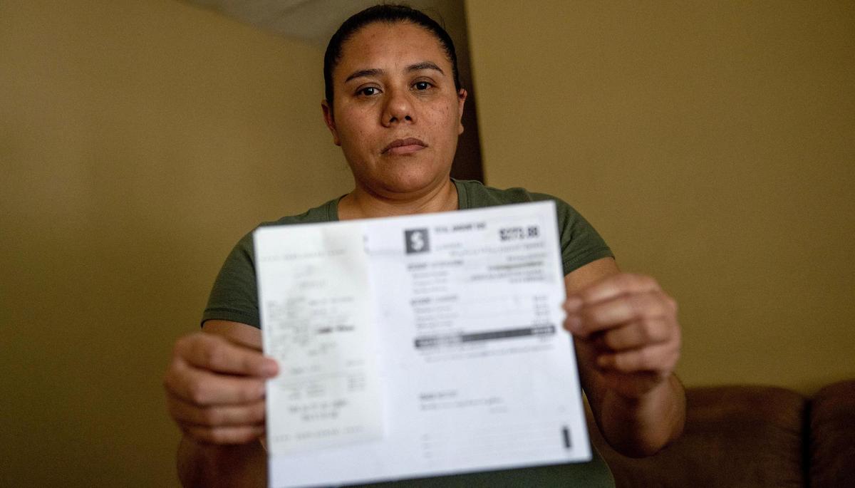 Jessica Martinez poses for a photo with a receipt showing she paid KC Water $610 on Friday, May 26, 2023, in Kansas City. Due to an outstanding balance left by a previous tenant, KC Water shut off water to Martinez’s home in April. Since then, her family has had to get creative for their water needs including transporting old pop bottles and buckets full of water by car to their home and using bottled water to brush their teeth.