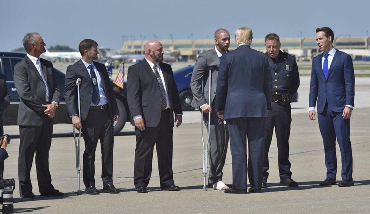 On his arrival Tuesday at Kansas City International Airport, President Donald Trump met with Kansas City Police Chief Rick Smith, second from right, and three police officers who were recently wounded in a shootout with a murder suspect. Also on the tarmac to greet Trump were Kansas City Royals baseball legend George Brett, far left, and Missouri Attorney General Josh Hawley, far right.