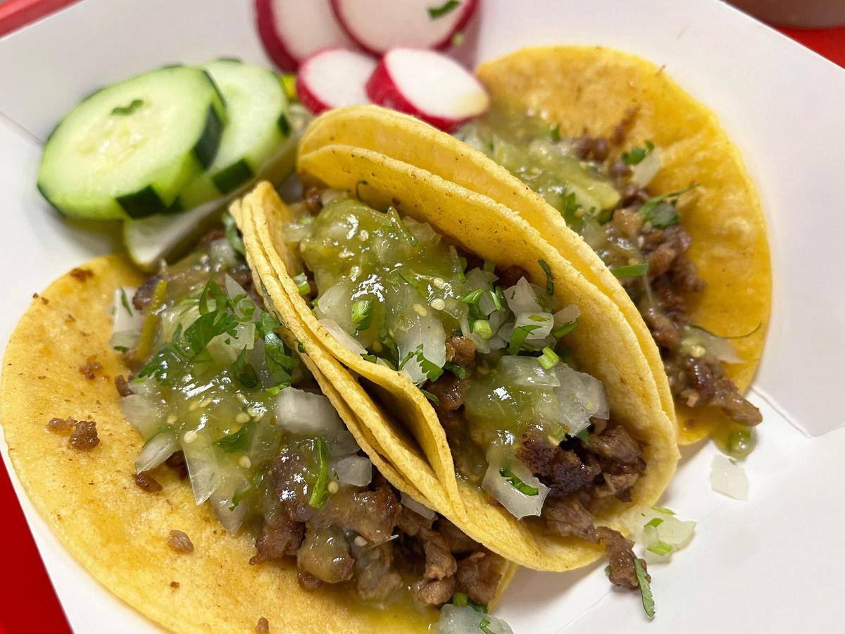 Three carne asada tacos are served alongside cucumber and radishes at Tacos El Gallo in Kansas City.