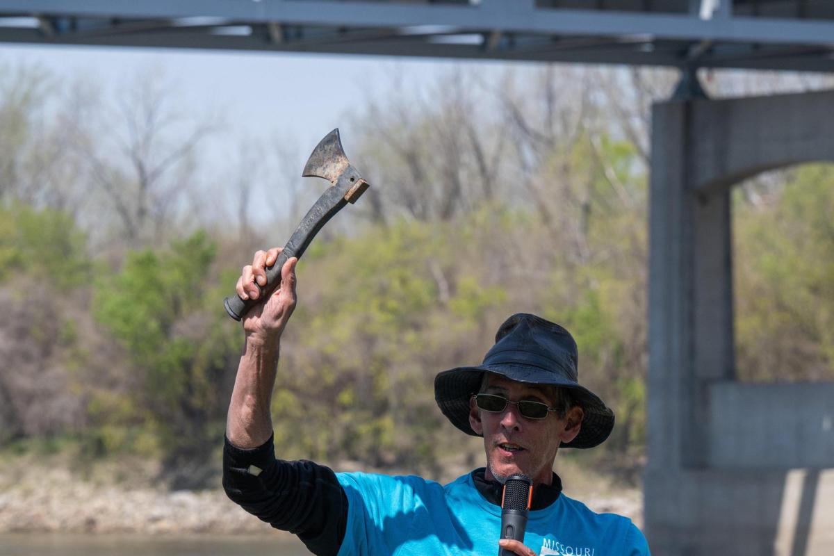 A volunteer holds up a hatchet found in the muddy riverbank along the Missouri River.