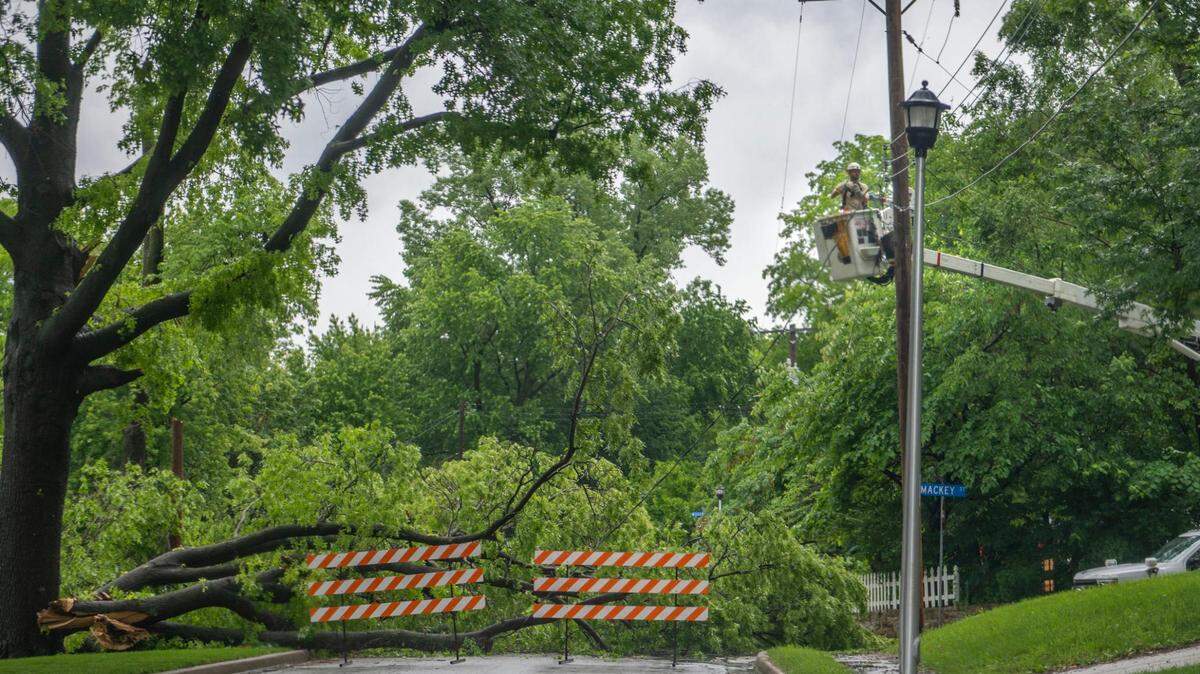 A crew member from Evergy works on electrical wires damaged by a fallen tree on Tuesday, May 31, 2022, at W. 57th and Mackey Streets in Merriam. Flooding concerns worsen as record rain falls in the Kansas City metro area.