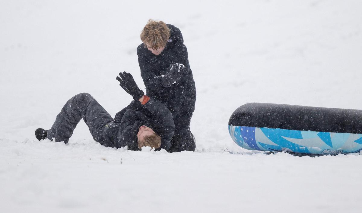 Children have a snow fight on the Brookside Hill on Tuesday, Jan. 9, 2024, in Kansas City.