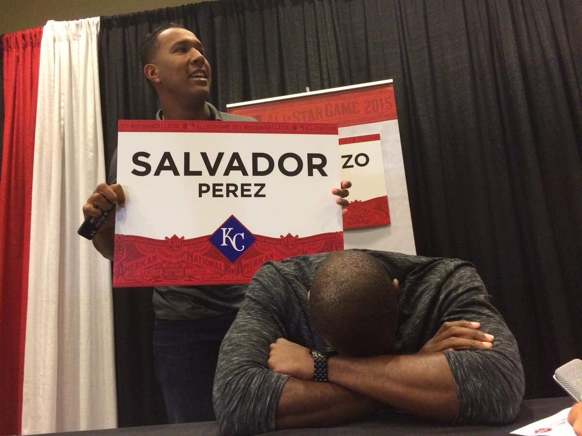 Royals catcher Salvador Perez, holding sign, hams it up at the expense of teammate Lorenzo Cain.