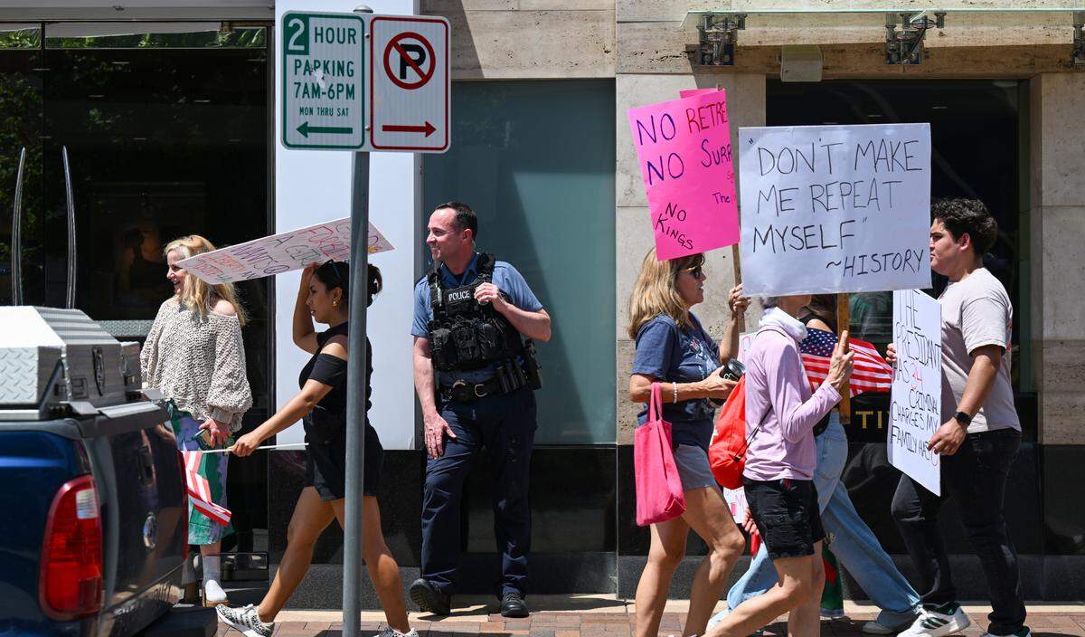 A KCPD officer watches over the demonstrations during the “No Kings” rally Saturday, June 14, 2025, at Mill Creek Park in Kansas City.