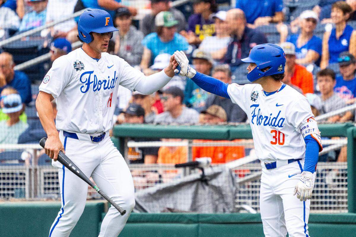Florida Gators first baseman Jac Caglianone (14) and right fielder Ashton Wilson (30) celebrate after a run scored by Caglianone against the Kentucky Wildcats during the first inning at Charles Schwab Field Omaha on Jun 19, 2024 in Omaha, NE, USA.