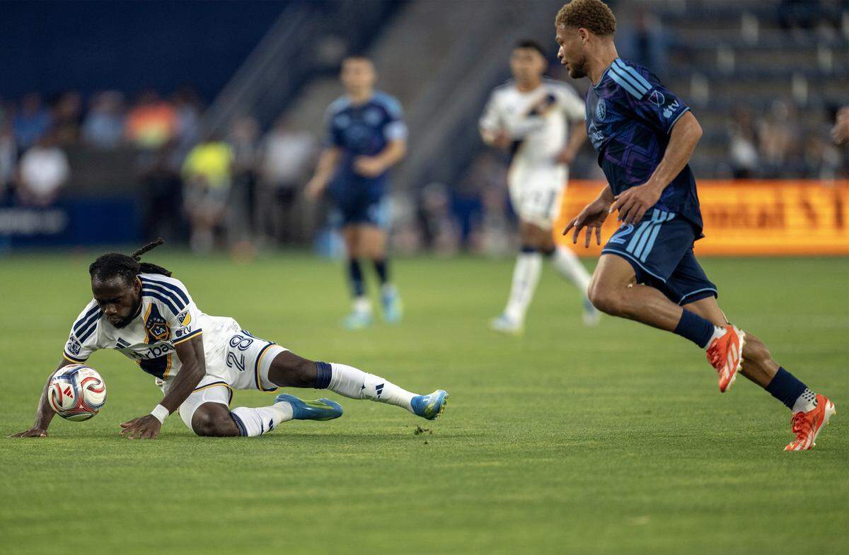 LA Galaxy forward Joseph Paintsil (28) hits the pitch as Sporting Kansas City defender Zorhan Bassong (22) comes on in the first half at Sporting Park on Wednesday, May 13, 2026, 2026, in Kansas City, Kansas,