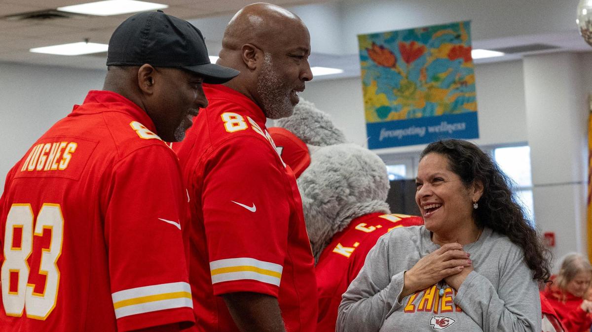 Rebecca Leistico reacts with surprise as former Chiefs wide receiver Danan Hughes and tight end Keith Cash visit the Don Bosco Senior Center on Monday.